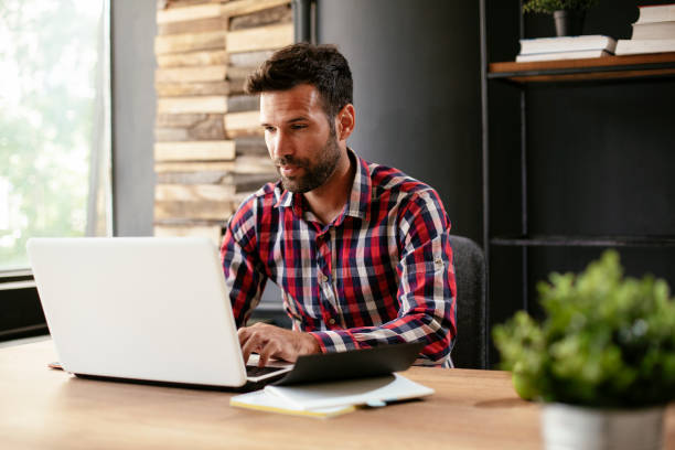 istock Stylish businessman working on a project in the office. 1295979633