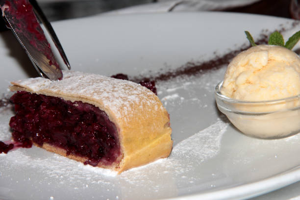 istock Cherry strudel with ice cream on a white plate 1295981868