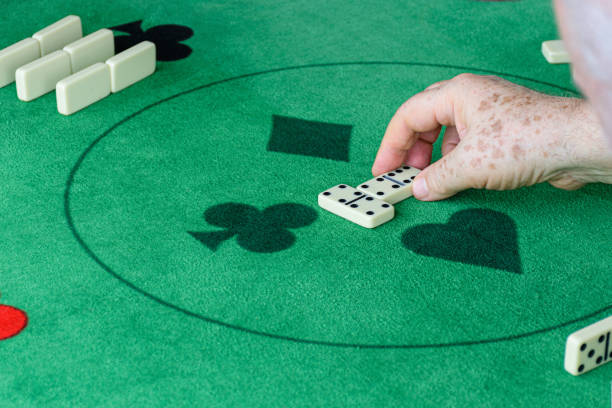 istock An elderly man starting a domino game. 1295983016