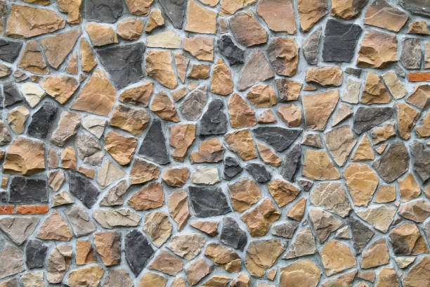 istock colorful beige tan black grey stone wall with natural concrete grout in a random pattern in natural sunlight 1295983256
