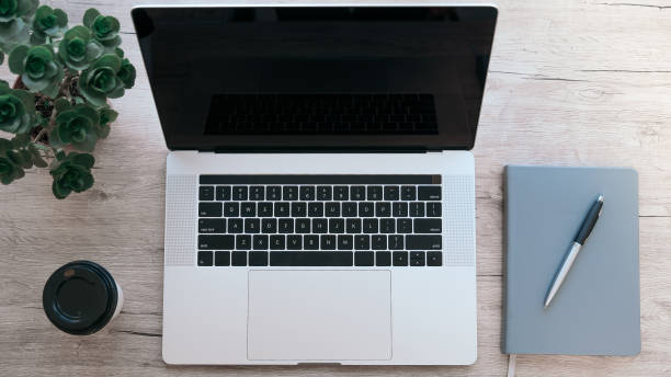istock top view. laptop, notebook and pen on the table 1295984213