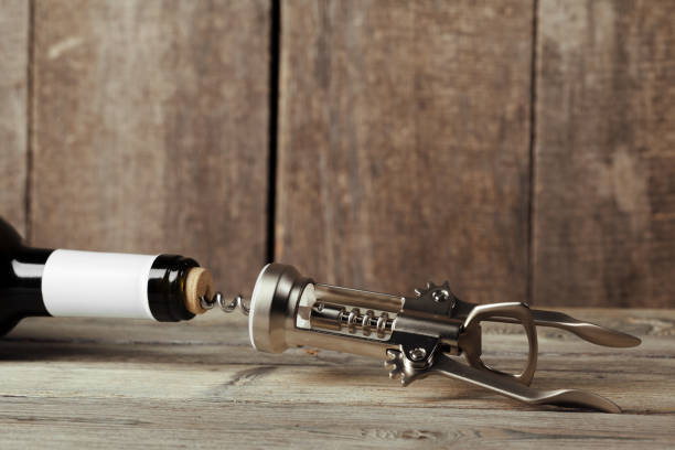 istock Bottle of wine with corkscrew on wooden background 1295984403