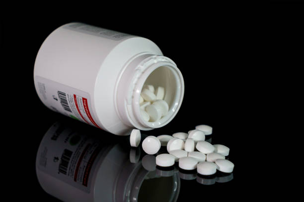 istock White pills spilling out of a toppled bright white pill bottle 1295984581