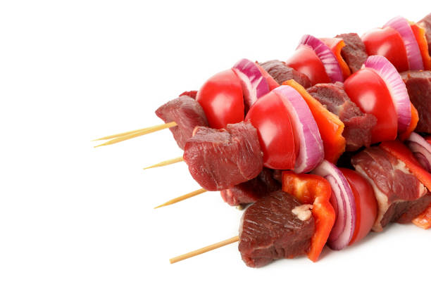 istock Skewers with raw meat and vegetables isolated on white background 1295985573