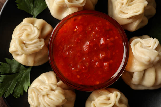 istock Plate with khinkali and sauce, top view and close up 1295986778