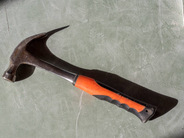 istock construction hammer on drywall. the view from the top, hard shadows. Tools for the job 1295987349