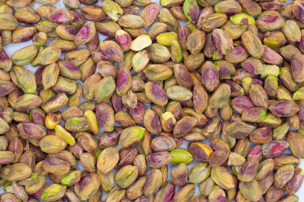 istock Fresh raw peeled pistachios isolated on white background 1295988179