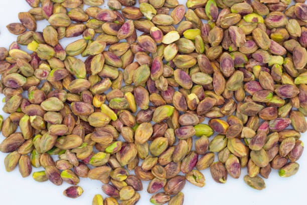 istock Fresh raw peeled pistachios isolated on white background 1295988722