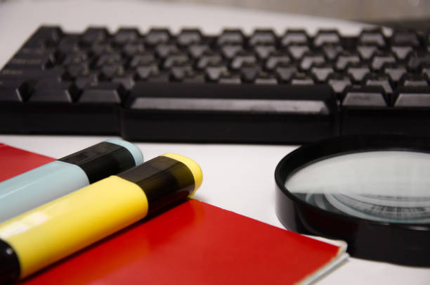 istock keyboard, green notepad, magnifier, markers lie on a white background 1295989011