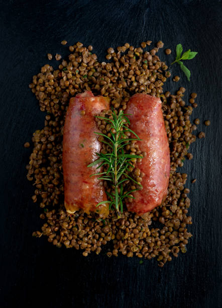 cotechino de porco com lentilhas na pedra de ardósia. - zampone - fotografias e filmes do acervo