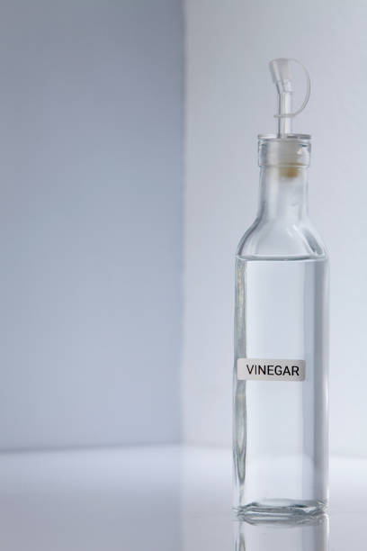 istock Bottle of white vinegar on gray white background 1295989258