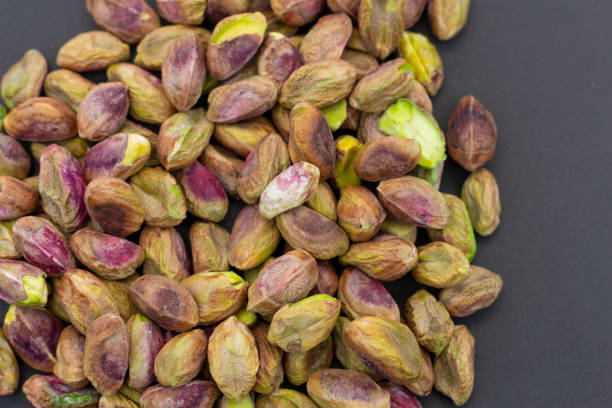 istock Fresh raw peeled pistachios isolated on Black background 1295989272