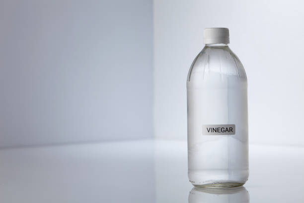 Bottle of white vinegar on gray white background Bottle of white vinegar on gray white background vinegar bottle stock pictures, royalty-free photos & images