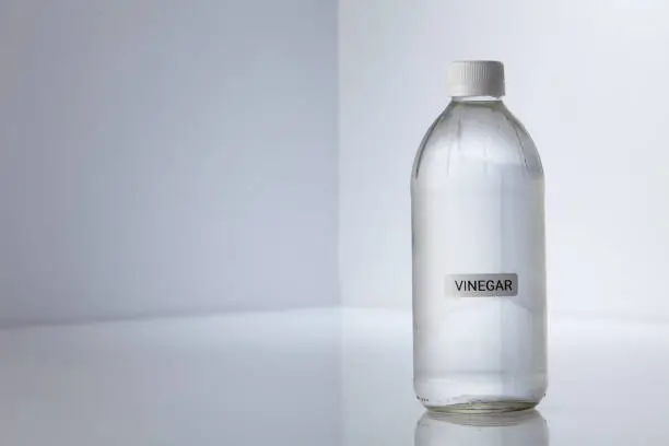 Photo of Bottle of white vinegar on gray white background