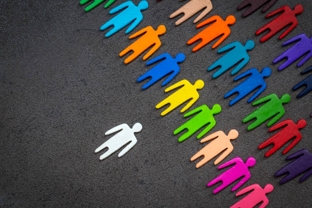 istock Equality and diversity concept. Multi-colored wooden figurines on a blackboard. 1295990487
