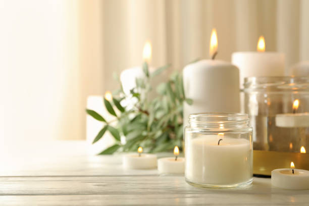 istock Burning scented candles for relax on white wooden table 1295992042