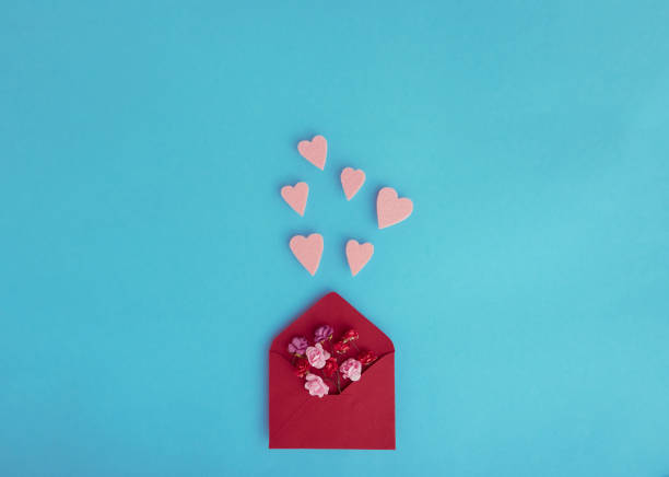 istock Paper red roses and envelope with fly hearts 1295993601