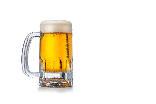 Beer mug on white background. Copy space Front view of a beer mug isolated on white background. The mug is cold and condensation drops are visible on it. The composition is at the left of an horizontal frame leaving useful copy space for text and/or logo at the right. High resolution 42Mp studio digital capture taken with Sony A7rII and Sony FE 90mm f2.8 macro G OSS lens glass of beer stock pictures, royalty-free photos & images