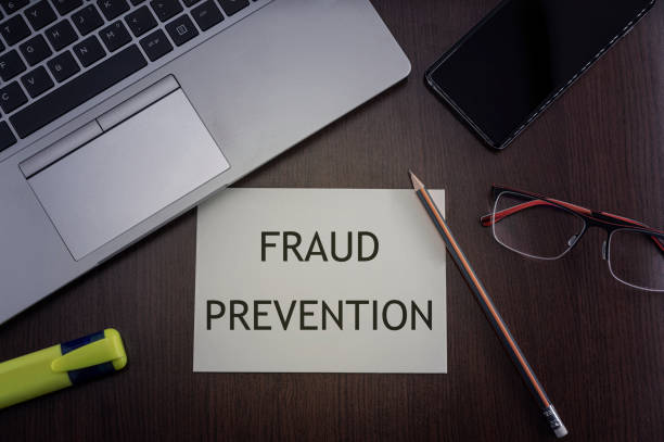 Fraud prevention card. Top view of office table desktop background with laptop, phone, glasses and pencil with card with inscription fraud prevention.  Security concept. stock photo