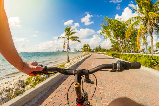 pov punkt widzenia strzał młodego sportowca jazda na rowerze przed rajskim błękitnym krajobrazem morza nad ceglaną ścieżką rowerową w key biscayne, miami beach, miami, south florida, stany zjednoczone ameryki - usa - bikers point of view zdjęcia i obrazy z banku zdjęć