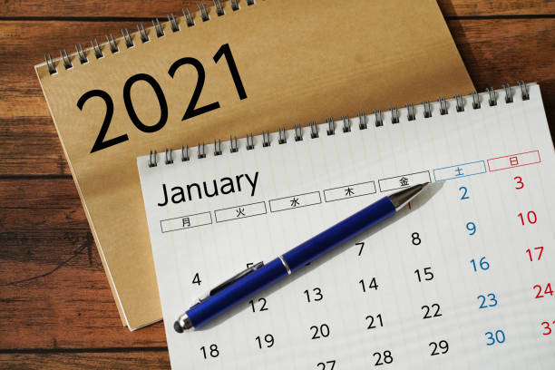 istock Calendar and schedule on wooden desk. 1295996450