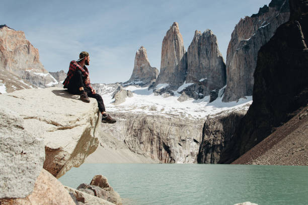 Man is looking at scenic view of Torres del Paine National Park Man is looking at scenic view of Torres del Paine National Park cuernos del paine stock pictures, royalty-free photos & images