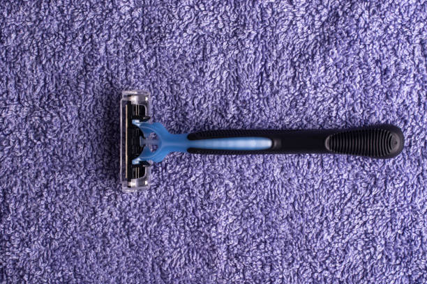 istock A disposable razor on a lilac towel. View from above. 1295997521