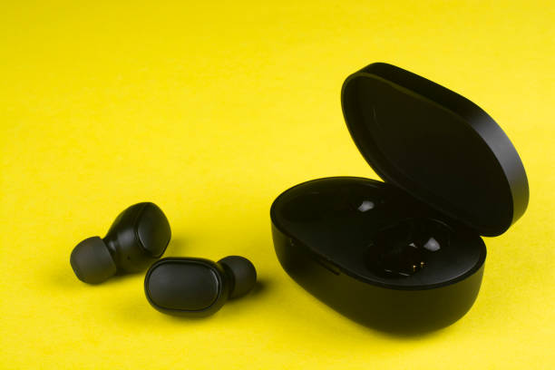 istock Black wireless headphones on a yellow background. 1295997523