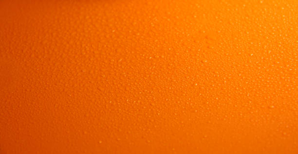 istock Wet orange background. Bright texture with water drops. 1295997618