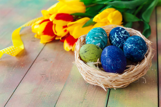 istock Easter eggs and tulips on wooden planks 1295998112