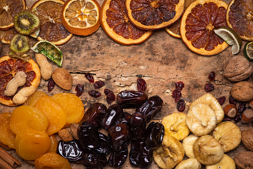 Dried fruit mix on a wooden table made of figs, dates oranges and apricots