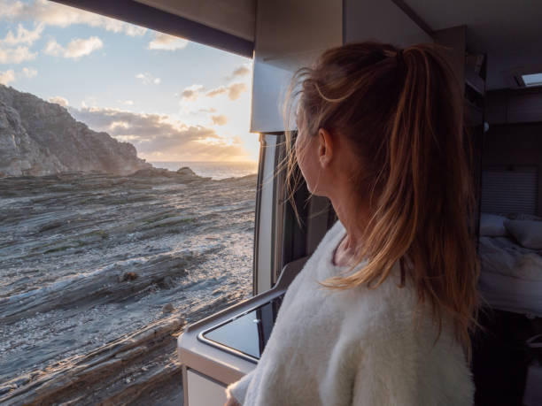 istock Woman looks at coastline from her van 1296000783