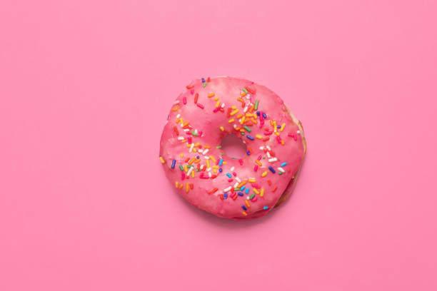 istock Single pink glazed doughnut donut on a pink background. 1296009352