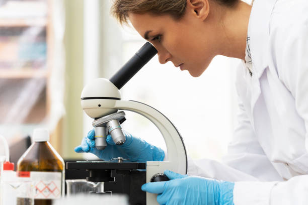 istock Woman scientist is using microscope in a laboratory during research 1296009927