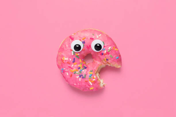 istock Shocked pink glazed doughnut donut with googly eyes on pink 1296011390