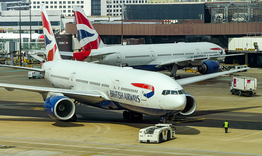London, England - April 2019: British Airways Boeing 777 jet being pushed back for departure. The aircraft is used on long haul flights across the world.