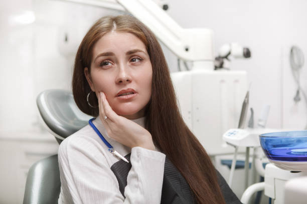 Female patient at ental clinic Close up of a woman suffering from toothache, sitting in dental chair at the clinic easy test stock pictures, royalty-free photos & images