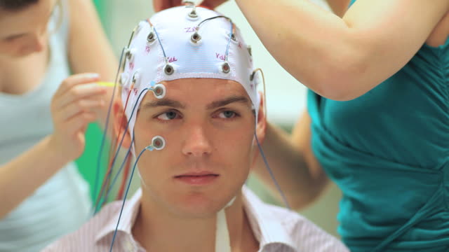 man connected with cables to computer - EEG for resarch