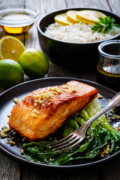 istock Fish dish - salmon steak with pak choi cabbage on wooden table 1296015357