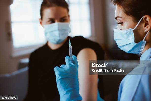 Nurse Giving Vaccine To Young Woman During Covid19 Season Stock Photo - Download Image Now