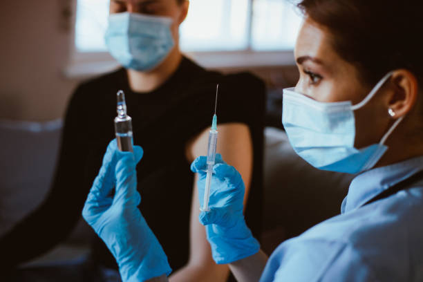 istock Nurse is preparing syringe for vaccination. Patient rolled a sleeve and waits. 1296015937