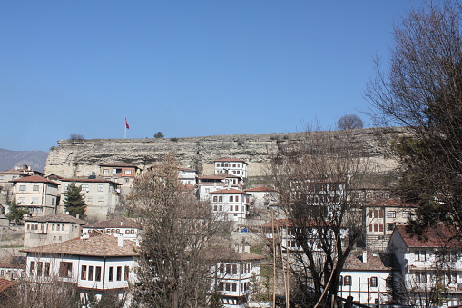 Karabuk, Turkey-February 5, 2011: Traditional Safranbolu Houses, Safranbolu. Houses Are Located Under Large Rock Formations. clear sky. Small houses with whitewashed wooden windows.