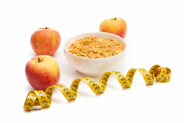 istock Apples and cereal bowl next to a meter. Diet concept. 1296018859