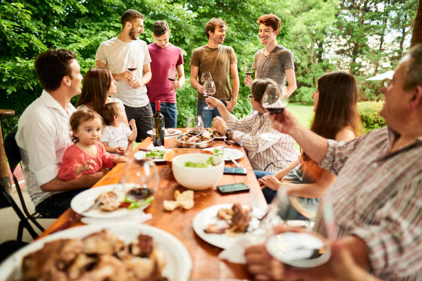 istock Young men laughing during a toast at a family dinner outside 1296020158
