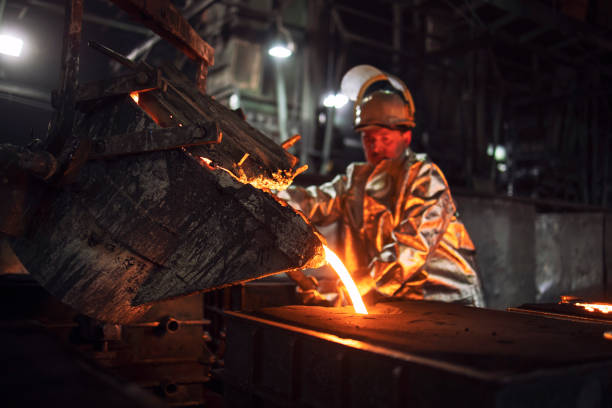 istock Foundry hardworking people pouring hot liquid iron from bucket into molds. Iron ore production and metallurgy. 1296020207