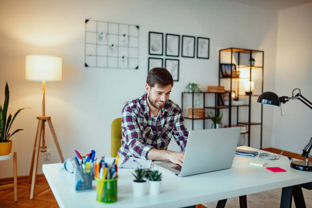 istock Entrepreneur working from home on laptop, wide angle shot with copy space 1296021464