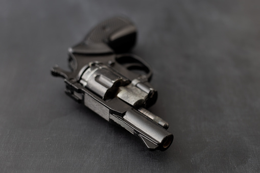 A Small revolver on black wooden table