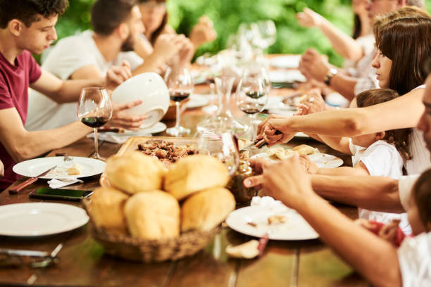 istock Multi-generational family having dinner outside around a table 1296024966