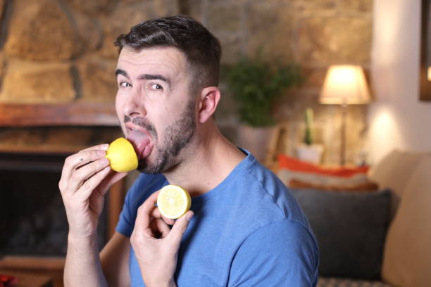 człowiek degustacja surowej cytryny - lemon sour taste biting eating zdjęcia i obrazy z banku zdjęć