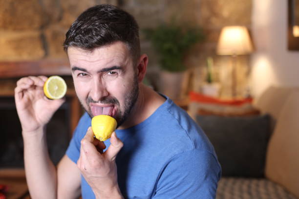 człowiek degustacja surowej cytryny - lemon sour taste biting eating zdjęcia i obrazy z banku zdjęć